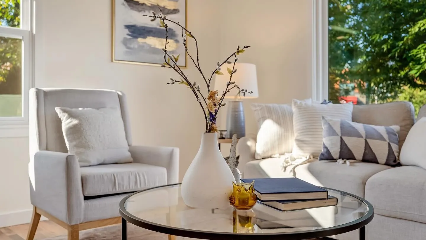 Staged living room with wingback chair and glass coffee table