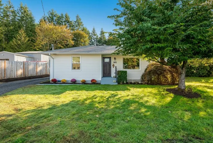 White rambler home with a manicured lawn