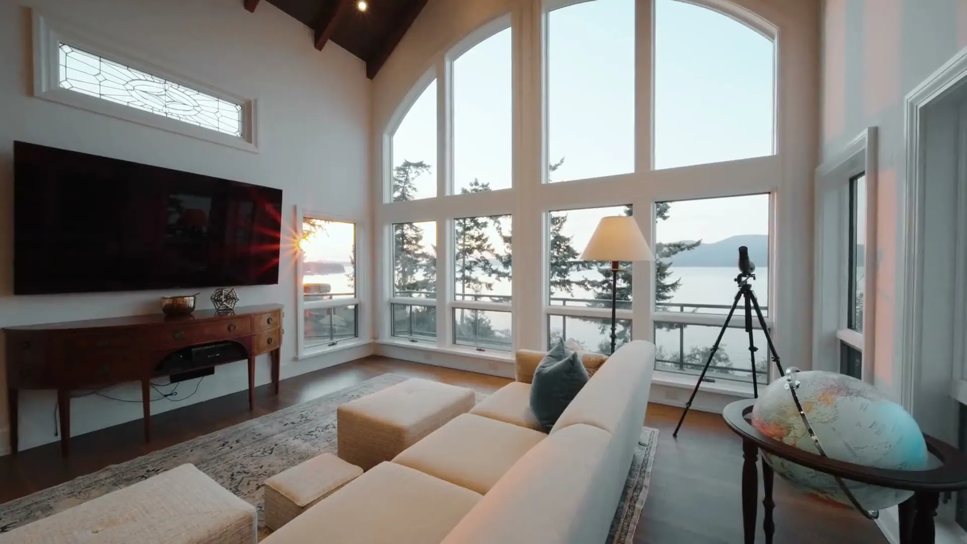 Bright living room with floor-to-ceiling arched windows overlooking the water