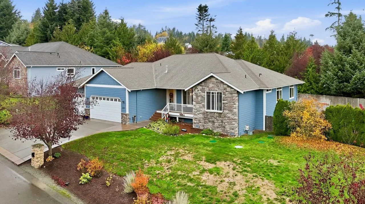 Blue rambler home with stone accents and autumn landscaping